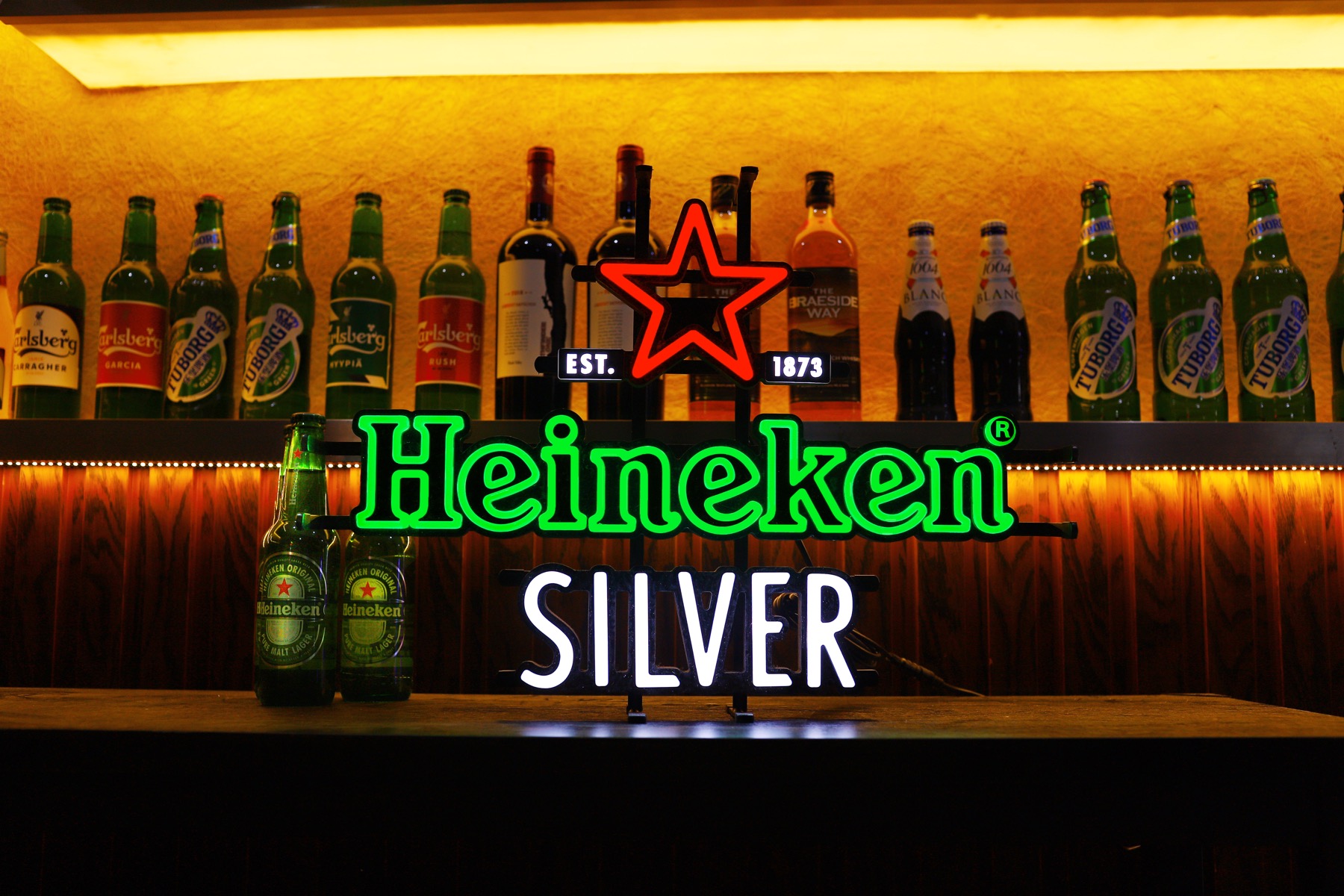 Illuminated logo sign showing lettering and a star in several colours