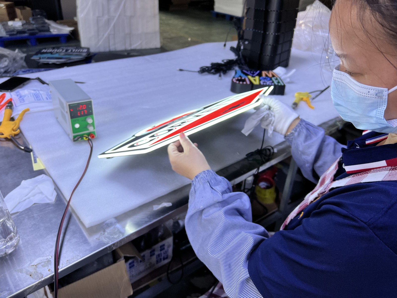 Illuminated sign connected to a bench power supply with voltage and current displays